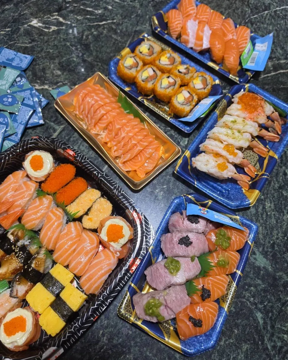 A spread of sushi, salmon sashimi, maki and prawn nigiri