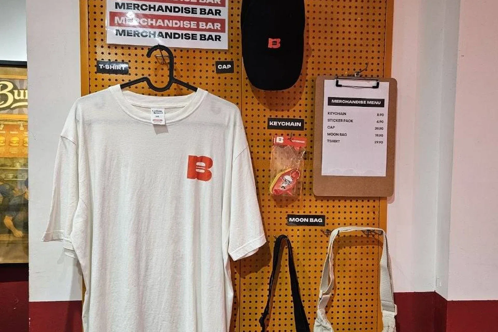 Burgs merchandise bar displaying a T-shirt, cap, keychain and moon bags